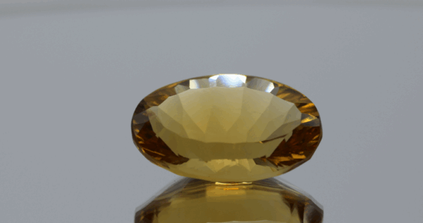 Natural oval cut citrine gemstone with yellow-orange color, 21.00 × 14.10 mm