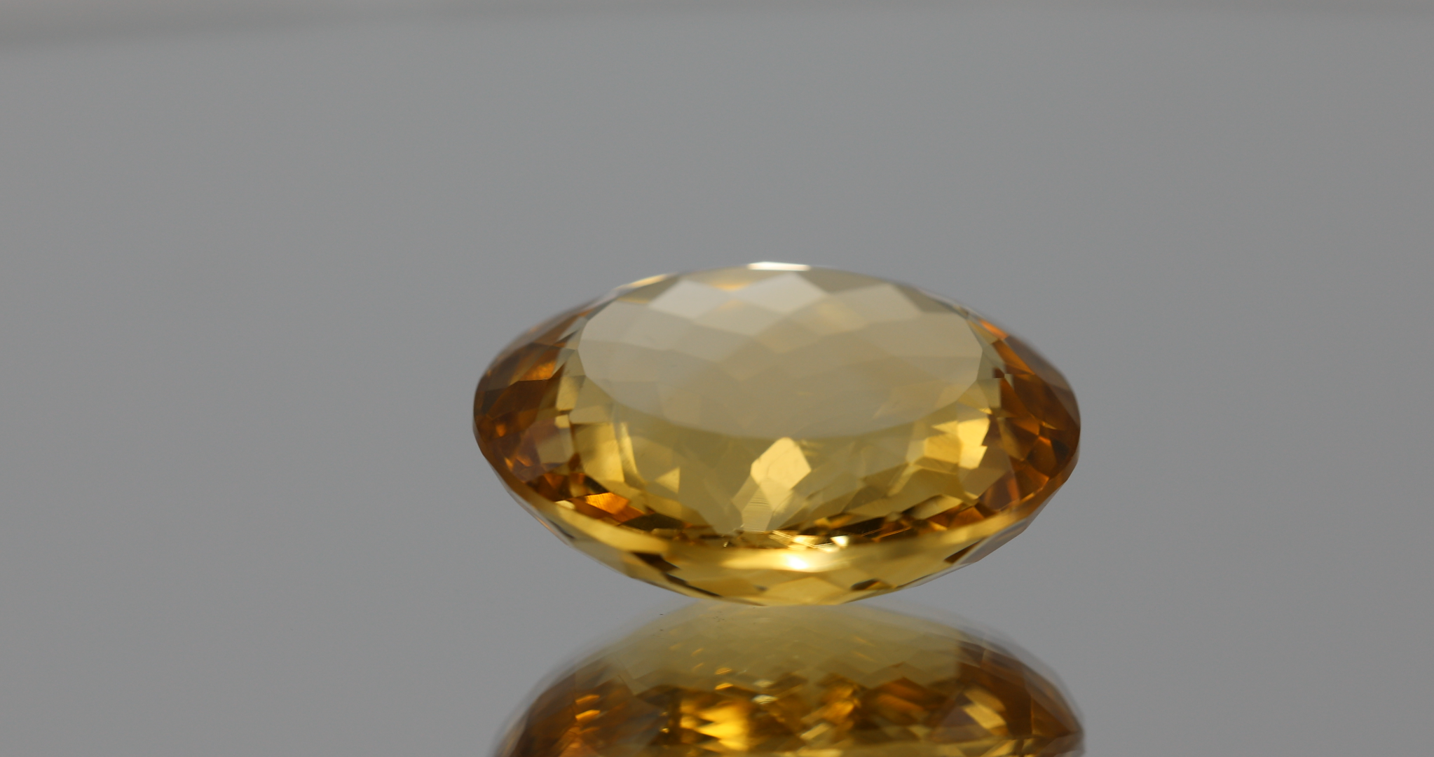 Natural oval cut citrine gemstone with yellow-orange color, 19.60 × 16.60 mm