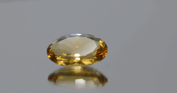 Natural oval cut citrine gemstone with yellow-orange color, 16.90 × 12.70 mm