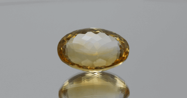 Natural oval cut citrine gemstone with yellow-orange color, 18.30 × 12.80 mm
