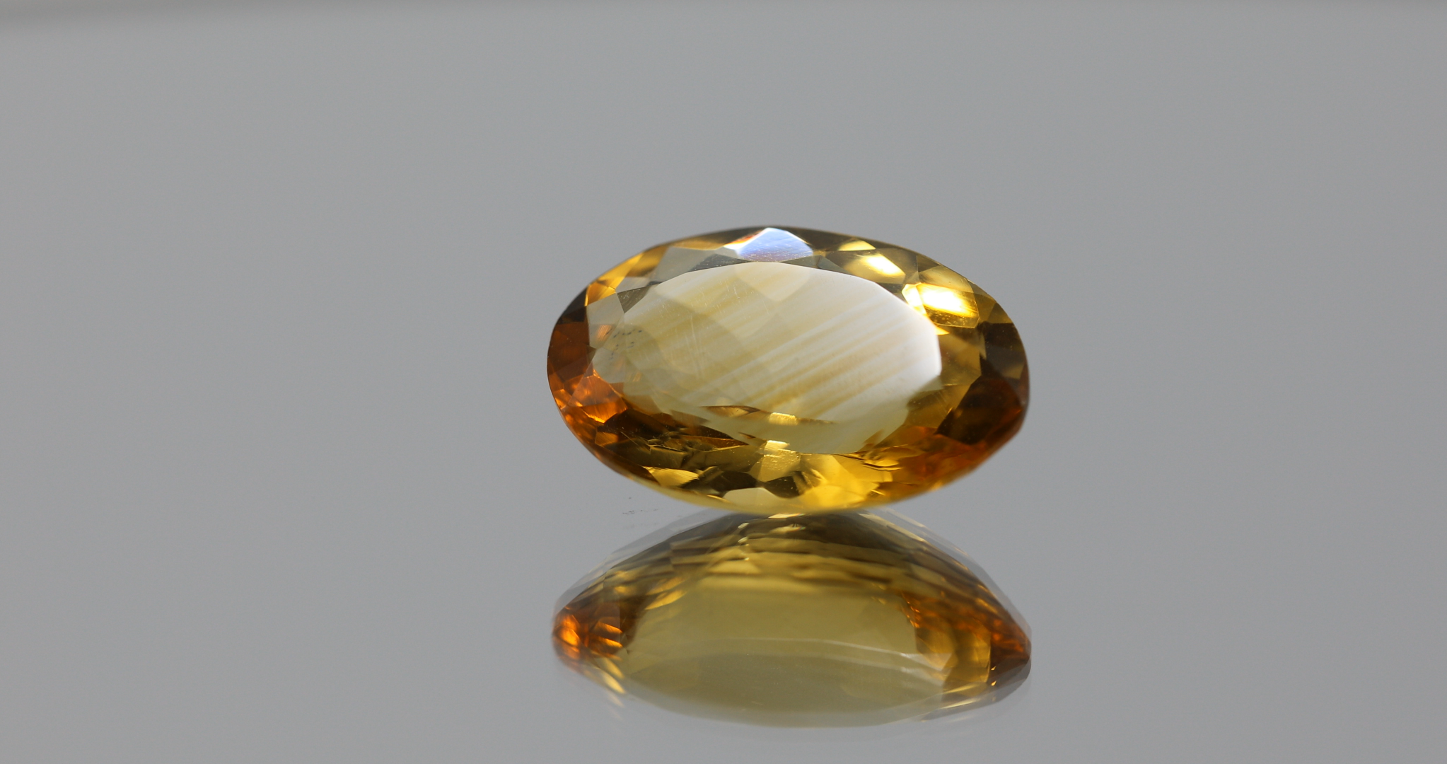 Natural oval cut citrine gemstone with yellow-orange color, 16.80 × 12.10 mm