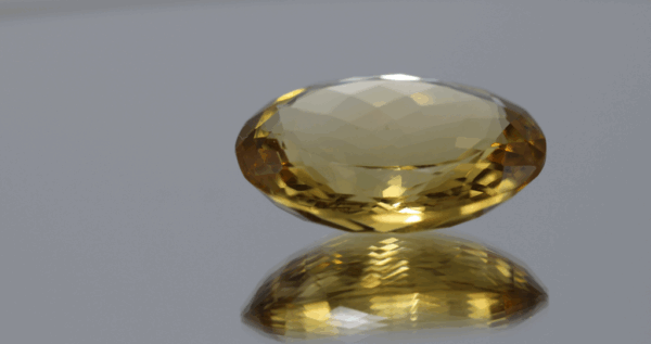 Natural oval cut citrine gemstone with yellow-orange color, 23.50 × 18.90 mm