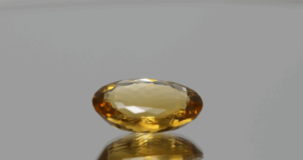 Natural oval cut citrine gemstone with yellow-orange color, 16.70 × 12.50 mm