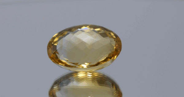 Natural oval cut citrine gemstone with yellow-orange color, 19.20 × 14.30 mm