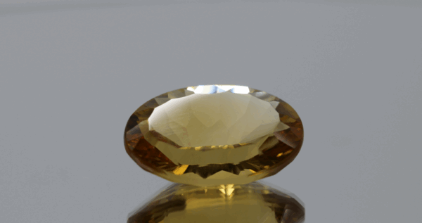 Natural oval cut citrine gemstone with yellow-orange color, 19.90 × 13.20 mm